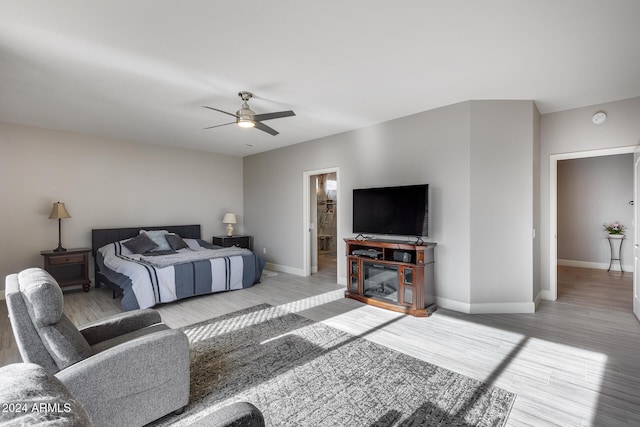 bedroom with ceiling fan, light hardwood / wood-style floors, and ensuite bath