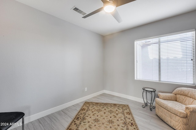 living area featuring a wealth of natural light and ceiling fan