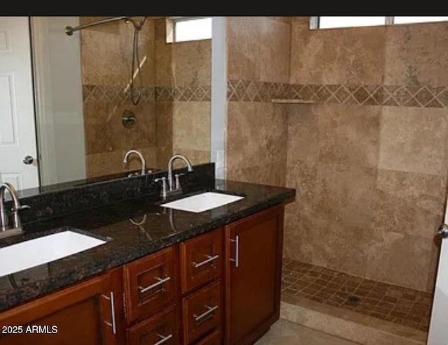 bathroom featuring tiled shower and vanity