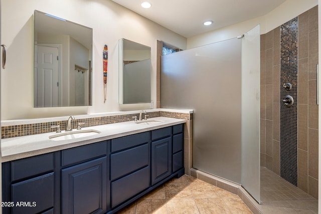 bathroom with double vanity, backsplash, a walk in shower, and a sink