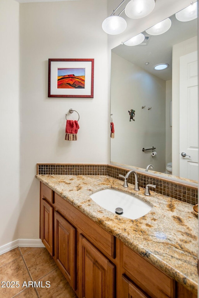 bathroom with tile patterned floors, baseboards, toilet, and vanity