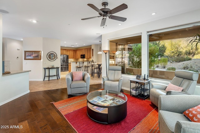 living area with recessed lighting, a ceiling fan, baseboards, and wood-type flooring