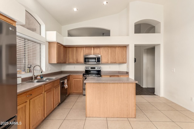 kitchen featuring a sink, a center island, light tile patterned flooring, and stainless steel appliances