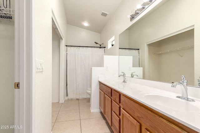 full bathroom featuring a sink, toilet, double vanity, and tile patterned floors