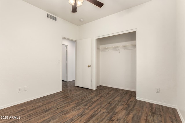 unfurnished bedroom featuring a closet, baseboards, visible vents, and dark wood-style flooring