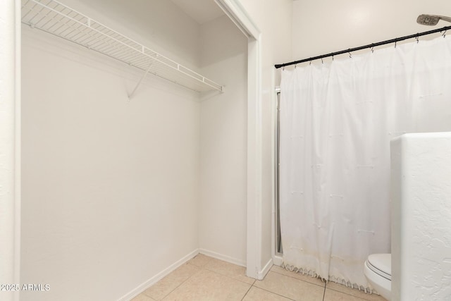 full bathroom with a shower with curtain, tile patterned floors, toilet, and baseboards