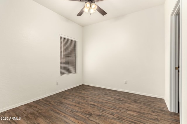 empty room with dark wood-type flooring, a ceiling fan, and baseboards