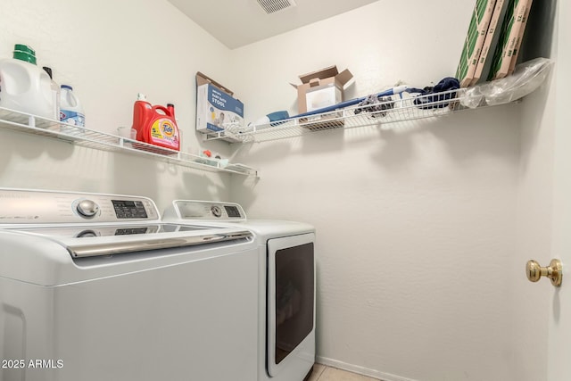 clothes washing area featuring visible vents, light tile patterned flooring, laundry area, and washing machine and clothes dryer