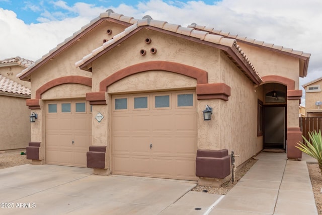 view of front of home with a garage, driveway, and stucco siding