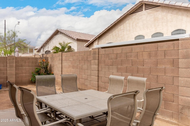 view of patio with outdoor dining space and fence