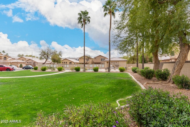 view of home's community with a yard, a residential view, and fence