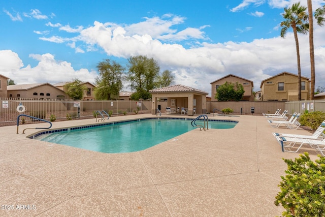 community pool with a patio and fence