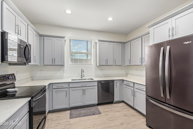 kitchen with appliances with stainless steel finishes, sink, and gray cabinetry