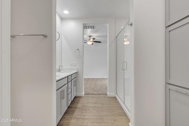 bathroom featuring hardwood / wood-style flooring, vanity, and a shower with door