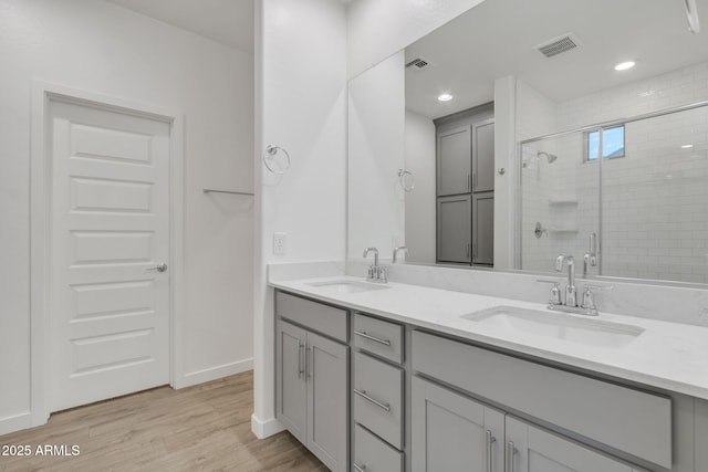 bathroom featuring vanity, hardwood / wood-style floors, and a shower with shower door