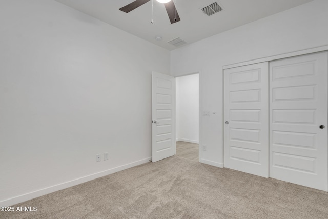 unfurnished bedroom with light colored carpet, ceiling fan, and a closet