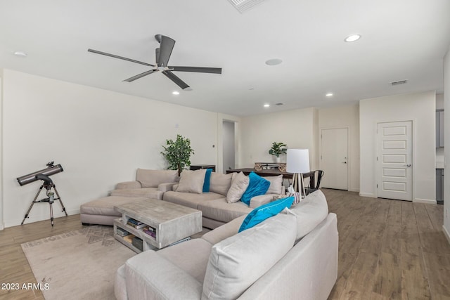 living room with light hardwood / wood-style flooring and ceiling fan