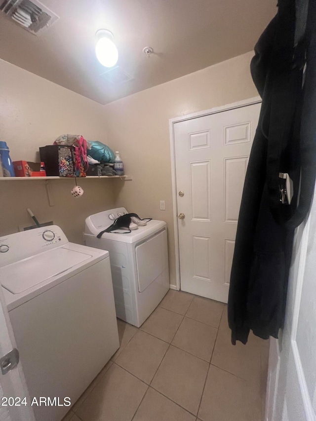 laundry area featuring washing machine and dryer and light tile patterned floors