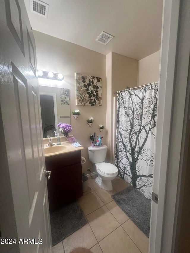 bathroom with tile patterned flooring, curtained shower, vanity, and toilet