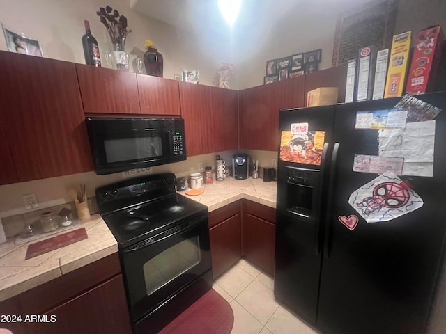 kitchen featuring black appliances, tile counters, and light tile patterned floors