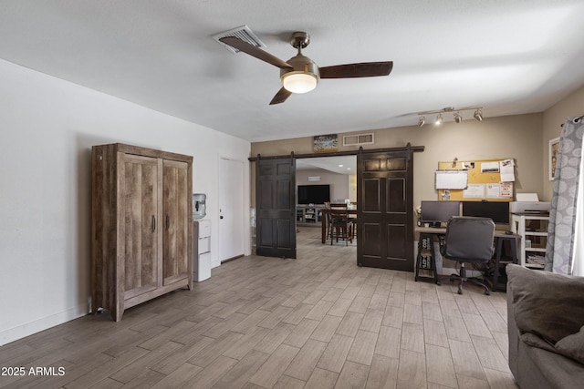 office space featuring a barn door and ceiling fan