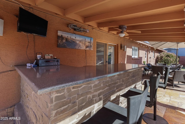 view of patio with a bar and ceiling fan