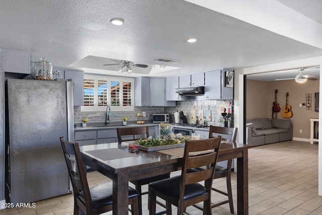 kitchen featuring gray cabinetry, sink, stainless steel appliances, and ceiling fan