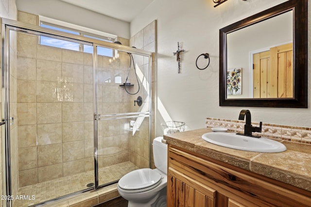 bathroom featuring vanity, walk in shower, and toilet