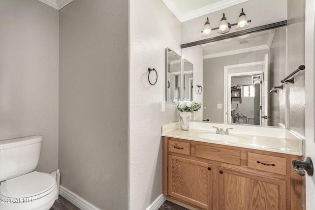 bathroom featuring toilet, vanity, and ornamental molding