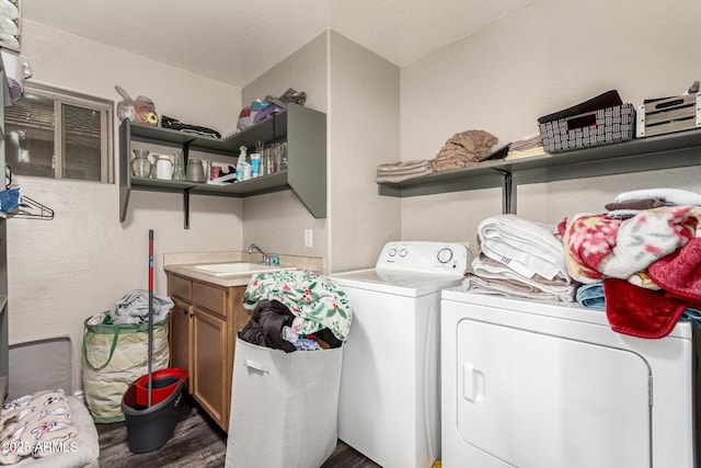 washroom featuring dark hardwood / wood-style flooring, cabinets, sink, and washing machine and clothes dryer