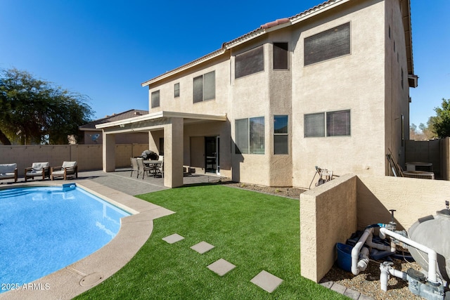 back of property featuring an outdoor living space, a patio area, a fenced in pool, and a yard