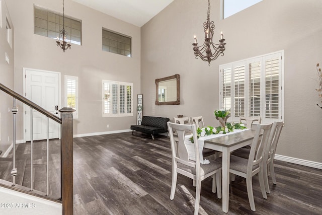 dining space featuring a notable chandelier, a towering ceiling, and dark wood-type flooring