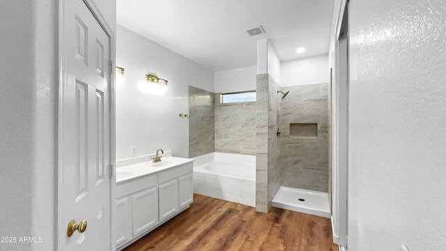6537 W Pioneer St, Phoenix, AZ 85043 - bathroom featuring a garden tub, a walk in shower, wood finished floors, and double vanity