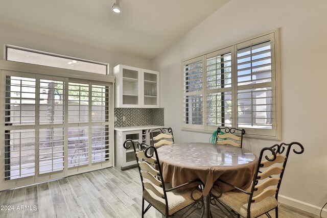 dining space featuring light wood-type flooring and lofted ceiling