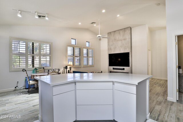 kitchen featuring vaulted ceiling, white cabinetry, ceiling fan, and light hardwood / wood-style floors