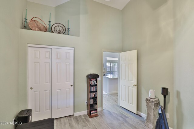 interior space with a high ceiling, a closet, and light hardwood / wood-style floors