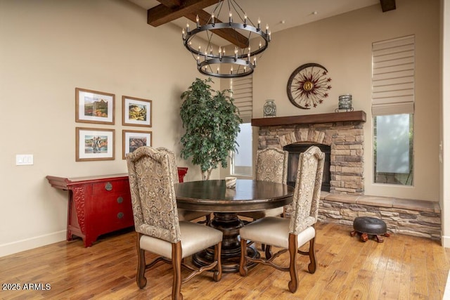 dining area with beam ceiling, wood-type flooring, and a chandelier