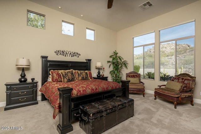 bedroom featuring multiple windows, light carpet, and ceiling fan