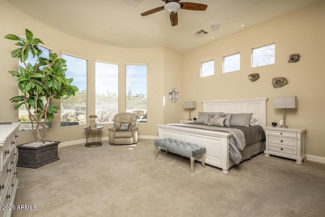 carpeted bedroom featuring multiple windows and ceiling fan