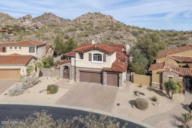 mediterranean / spanish-style house with a garage and a mountain view