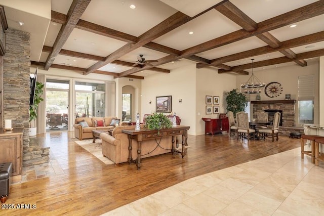 living room with a fireplace, coffered ceiling, beam ceiling, and light hardwood / wood-style flooring