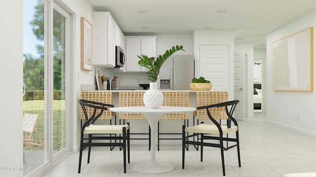 kitchen featuring white cabinets, light tile patterned floors, and white fridge with ice dispenser