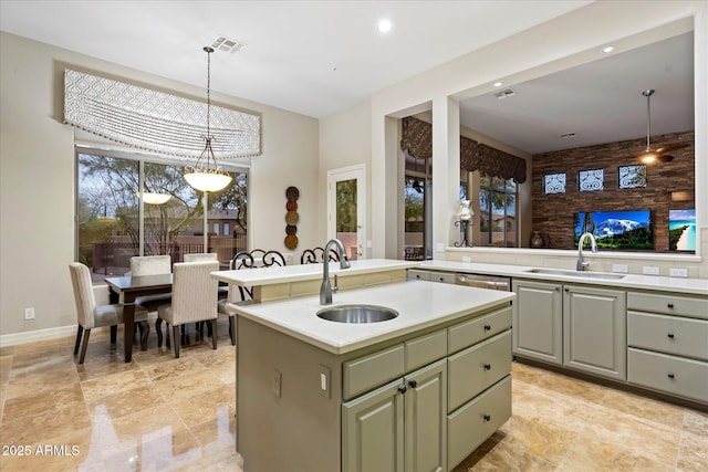 kitchen featuring pendant lighting, a kitchen island with sink, and sink