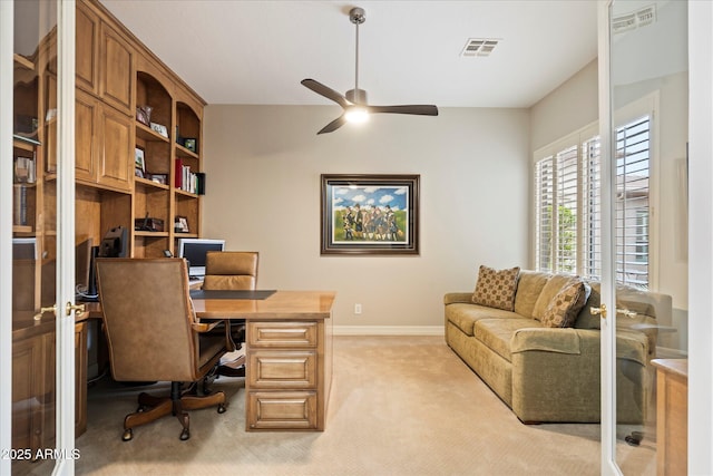 carpeted home office with french doors and ceiling fan