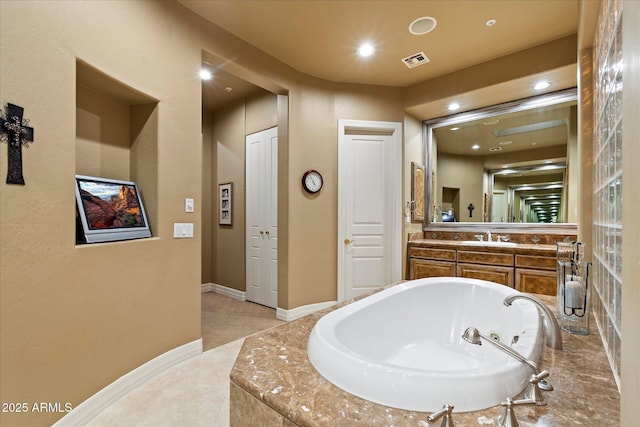 bathroom with vanity and tiled tub