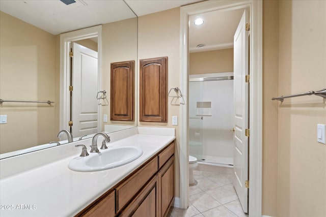 bathroom with vanity, toilet, a shower with shower door, and tile patterned flooring