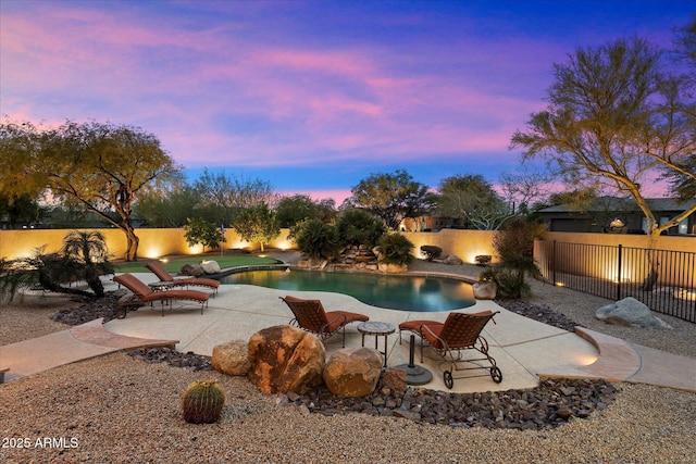 pool at dusk featuring a patio