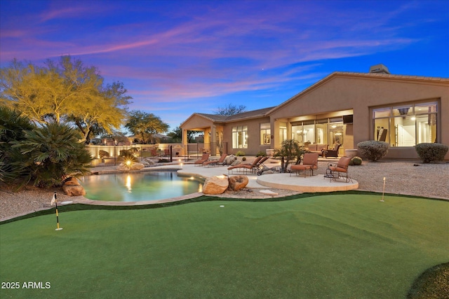 pool at dusk featuring an outdoor fire pit and a patio area