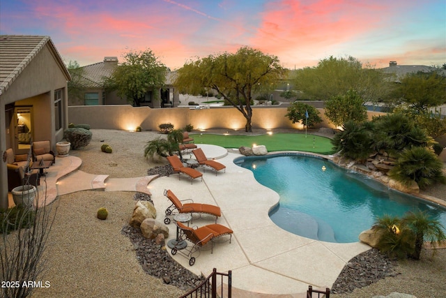 pool at dusk featuring a patio area