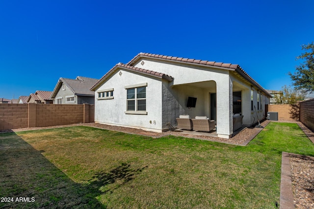 back of property with a lawn and an outdoor living space